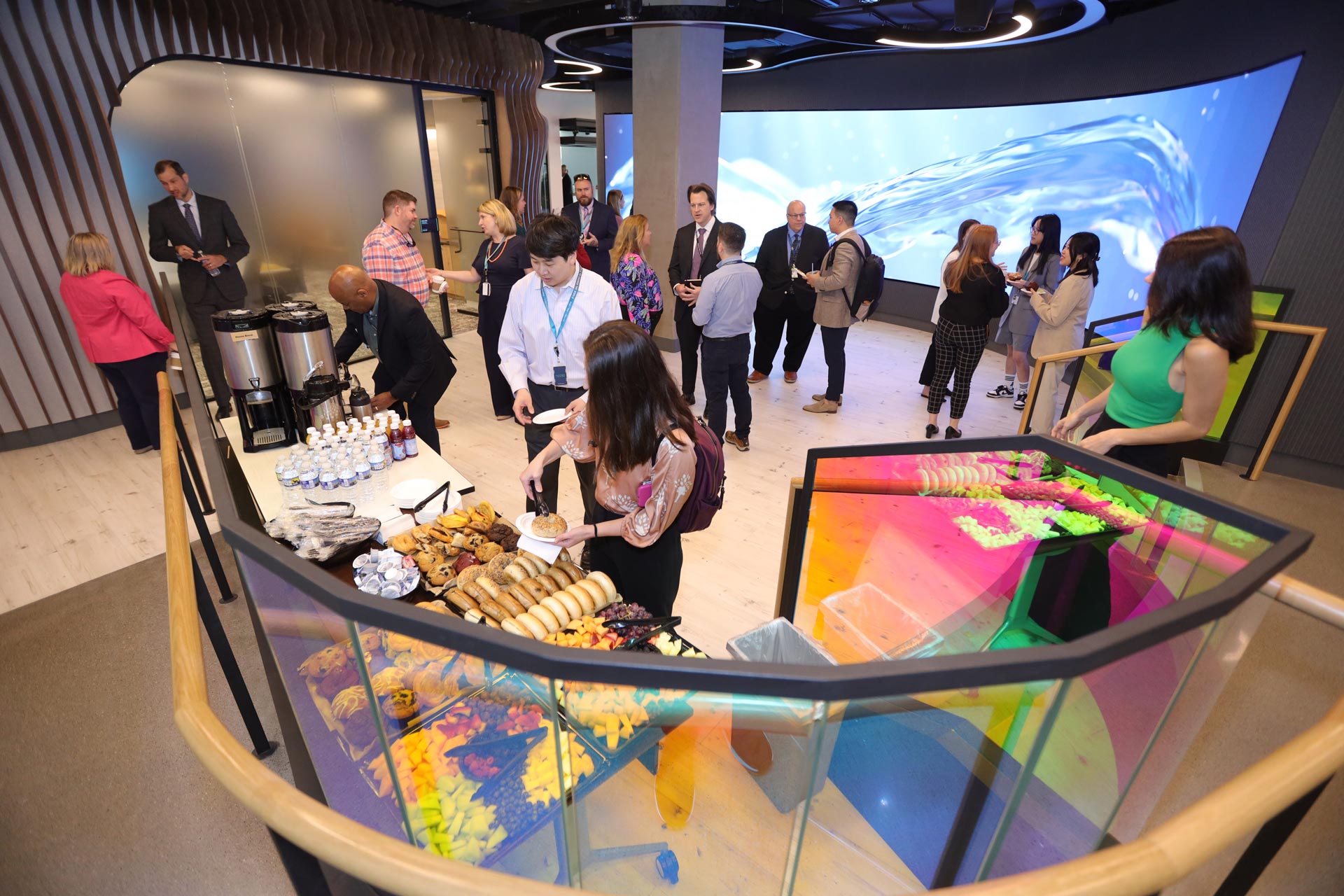 A collection of people enjoying refreshments at a social event hosted by the Helix