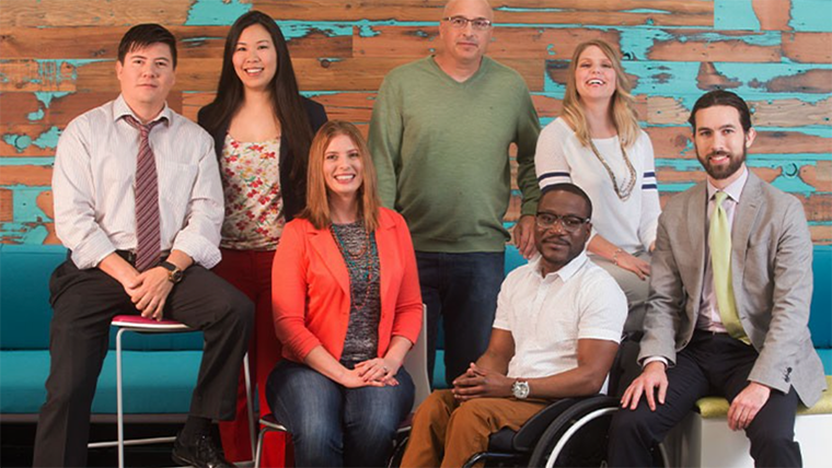 A group of diverse employees pose for a picture